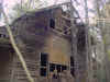 North end of house showing the fallen chimney and windows in the sleeping loft.